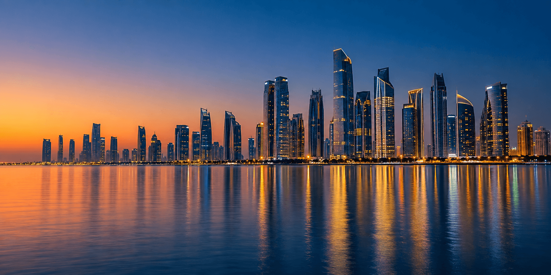 Modern city skyline at dusk seen across calm water with lights starting to glow